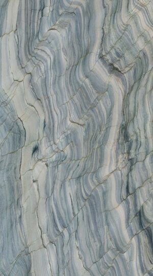 Fusion Polished Quartzite is an extraordinary spectacle of nature’s most daring artistry, capturing a dynamic and mesmerizing energy within each slab. The polished finish reveals a rich base of interwoven greens, unfolding from the warmth of olive and jade to cooler shades of seafoam and deep emerald. These verdant tones blend seamlessly, creating a visual rhythm that feels alive and continually evolving. The movement within the stone stands out as its most defining characteristic—a cascade of layered light and color that shifts and plays across the surface, evoking a sense of depth and vibrancy. Bands of light seem to hover just beneath the polished finish, offering an experience that is both sophisticated and powerfully captivating. This quartzite is not merely a surface but a transformative design element that commands attention and inspires awe. Its texture is a visual symphony of complex patterns and fluid motion, creating an almost hypnotic, psychedelic effect that seems to spin and evolve before your eyes. This powerful aesthetic makes Fusion Polished Quartzite an unparalleled choice for statement applications, such as a monolithic kitchen island, a dramatic feature wall, or a breathtaking countertop that serves as the centerpiece of a luxury space. For the discerning client seeking to infuse their environment with unparalleled energy and a piece of geological wonder, Fusion Polished Quartzite offers an unforgettable statement of bold, artistic expression and enduring quality.